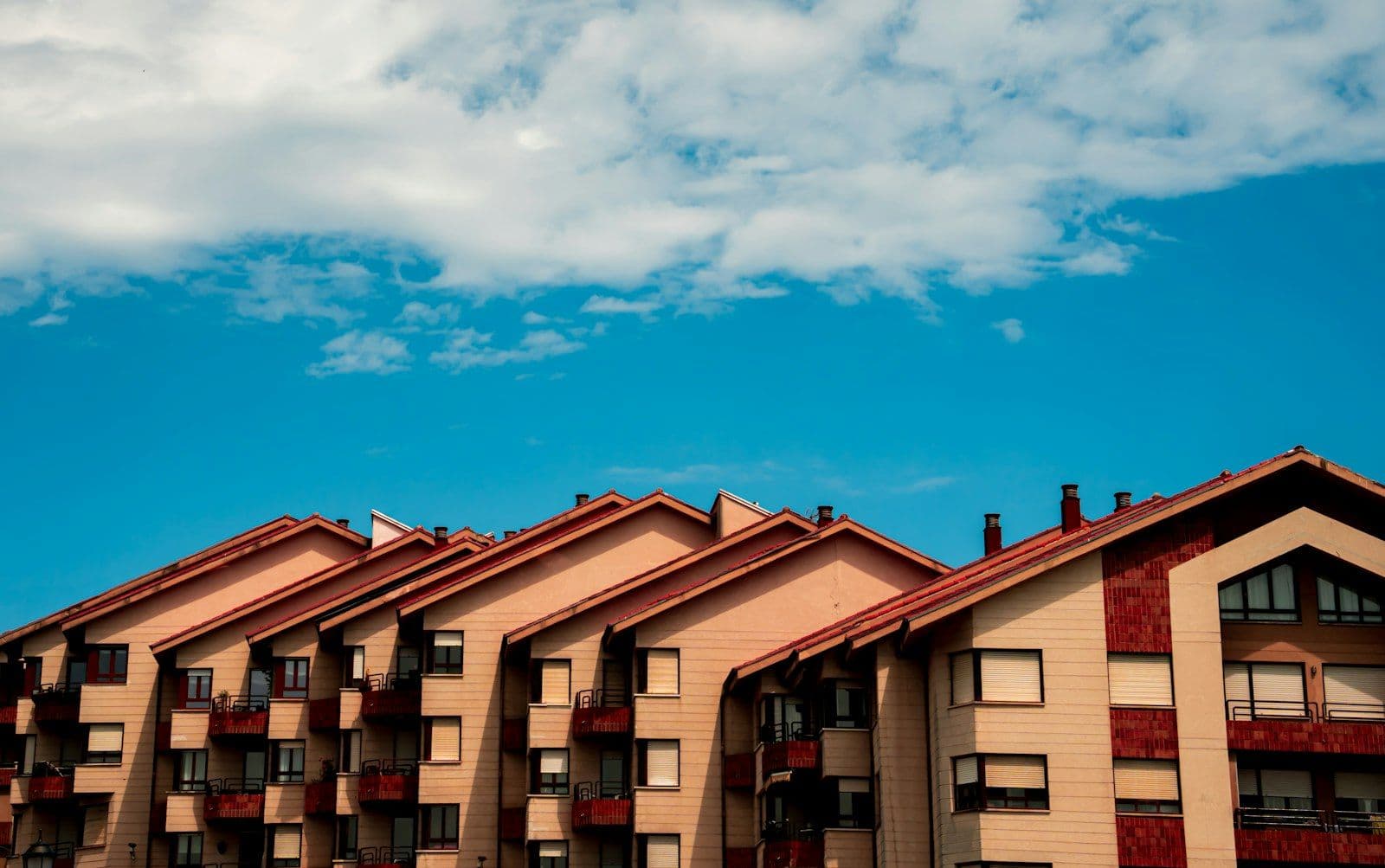 Prédios residenciais com telhados marrons sob céu azul